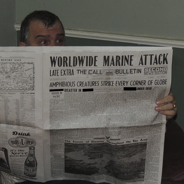 Detail view of  front page of "Dagon" newspaper with terrified man peeking over the top.